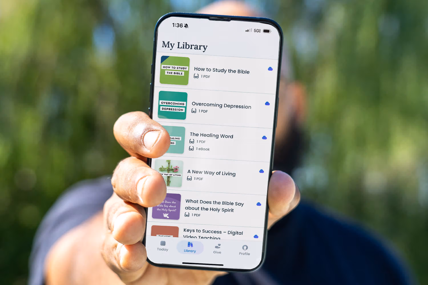Man holding his phone with the Joyce Meyer Ministries app on it