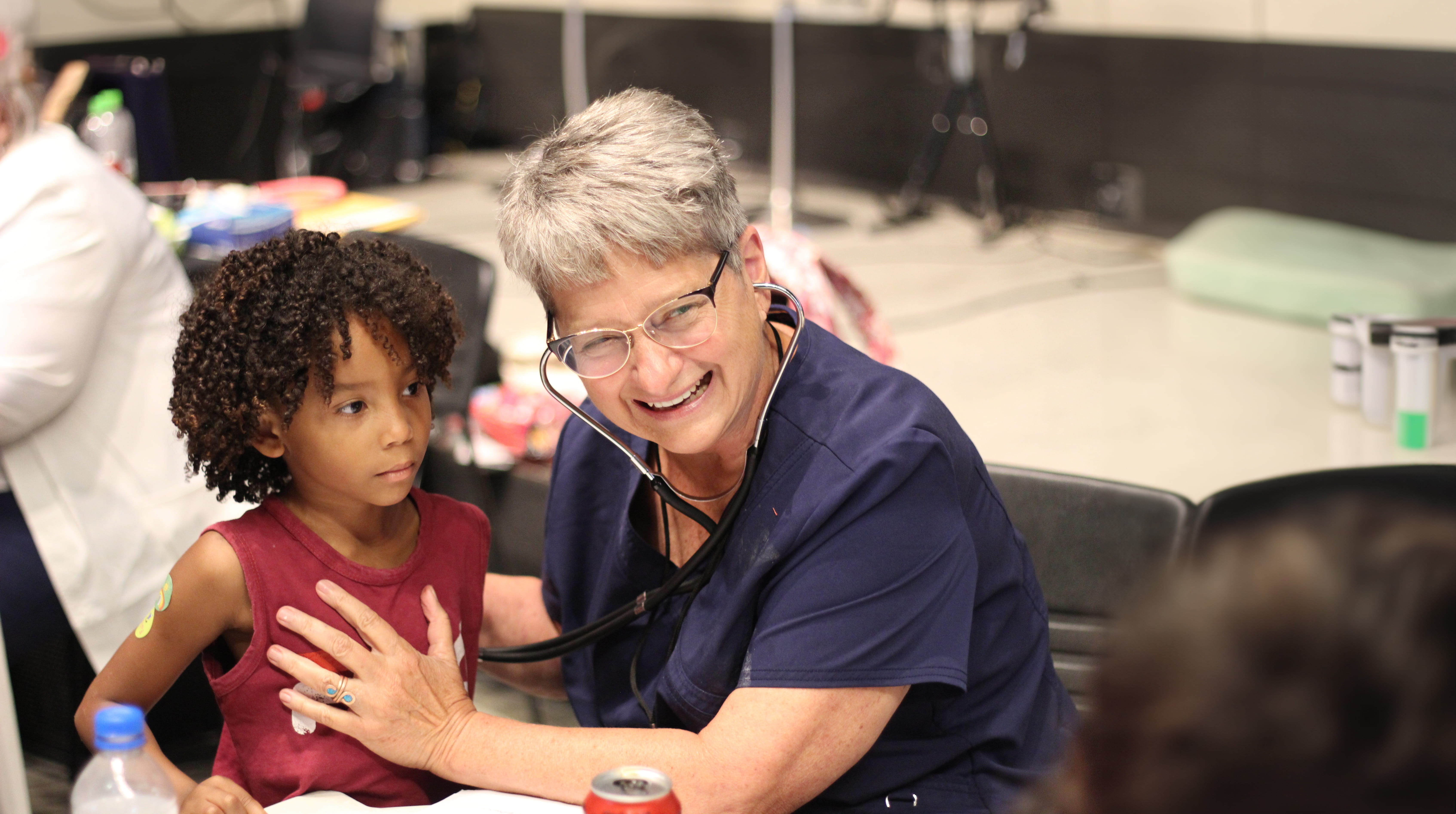 A smiling nurse taking care of a child patient.