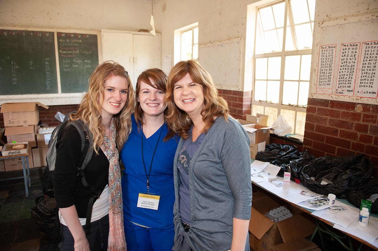 Image of three women standing together smiling.