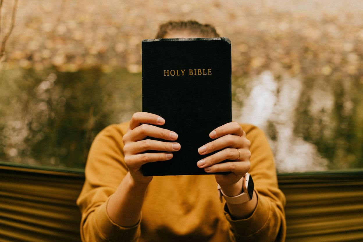 Image of a person holding up a Bible.