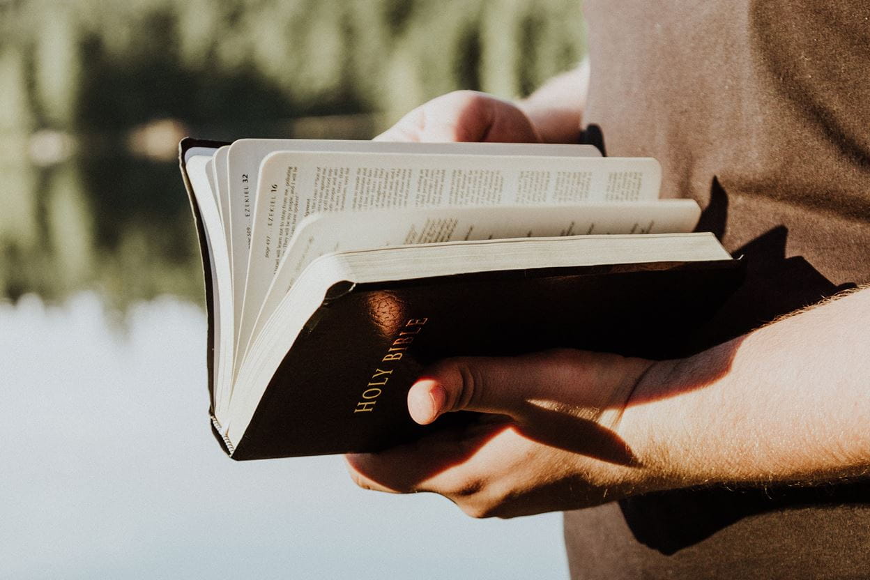 A man holding a Bible preparing to read a daily devotional.