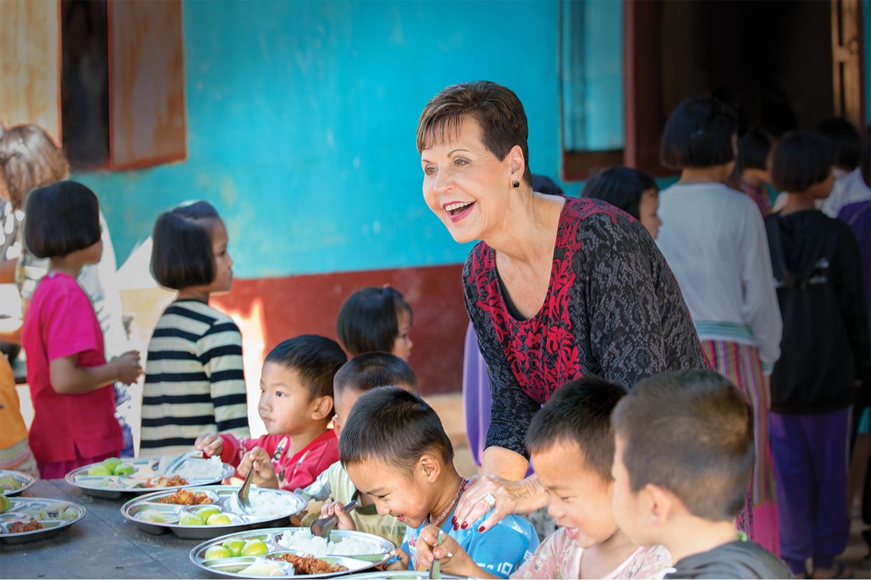 Joyce Meyer serving children a meal at a feeding center