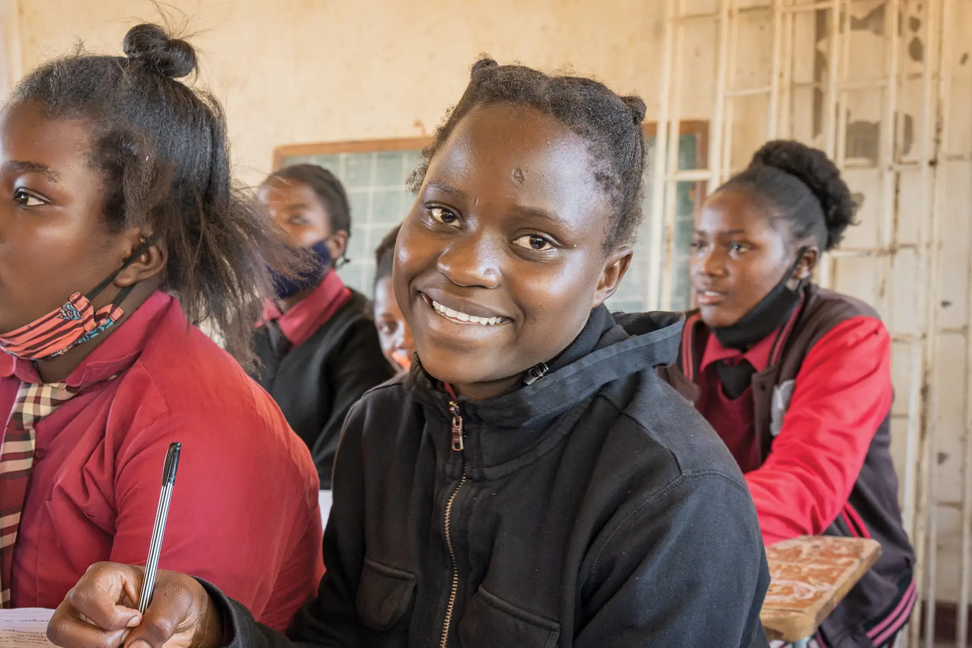 Racheal smiling, sitting in her classroom